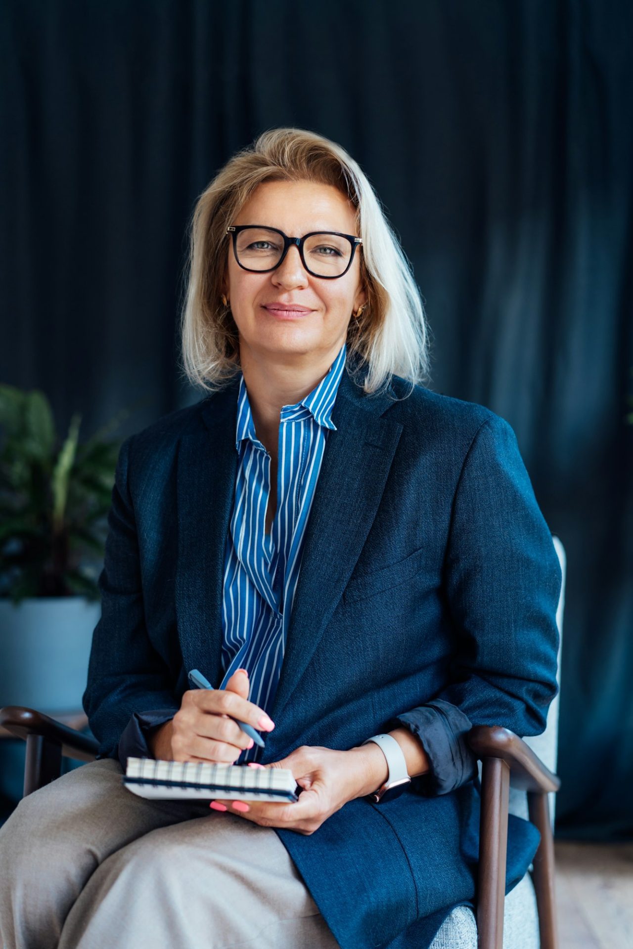professional psychotherapy successful female psychologist smiling to camera sitting on armchair.jpg